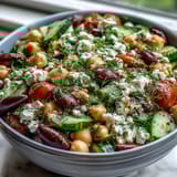 Hearty Greek Bean Salad with Lemon Marinated Beans features a vibrant medley of chickpeas, crisp cucumbers, and Kalamata olives.