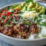 This Low Carb Burrito Bowl features seasoned ground beef and cauliflower rice on crisp lettuce.