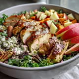 A colorful Harvest Bowl with warm roasted sweet potatoes, juicy chicken, crisp apples, and crunchy almonds layered over kale and wild rice, finished with creamy goat cheese.