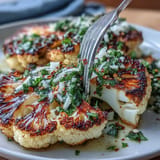 Smoky BBQ Cauliflower Steaks, perfectly grilled and drizzled with vibrant herb sauce.