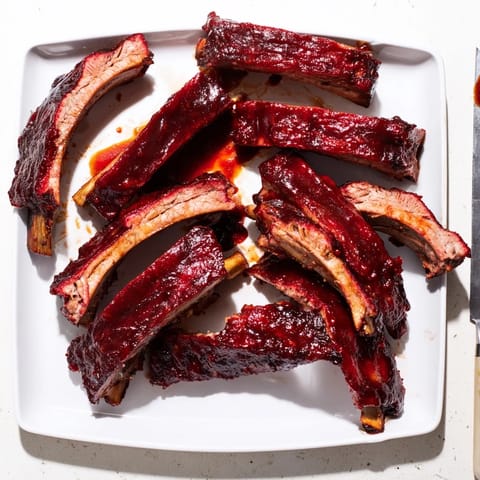 Golden, caramelized BBQ Ribs on a platter ready for a backyard feast.