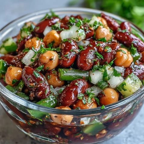 Colorful three-bean salad packed with fresh veggies for a picnic delight.