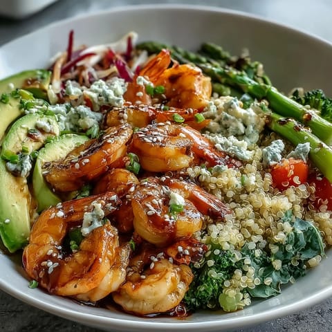 A close-up of the Rainbow Vegetable Detox Bowl shows bright red cabbage, green broccoli, and pink shrimp nestled on fluffy quinoa with creamy avocado.