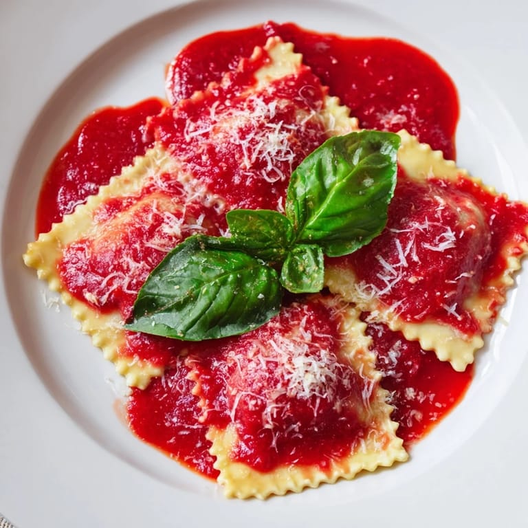 Homemade Spinach Ricotta Ravioli served in a warm marinara sauce, perfect for a comforting Italian dinner.