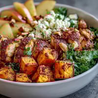 Roasted chicken and caramelized sweet potatoes top the Fall Sweet Potato Harvest Bowl with fresh kale and goat cheese.